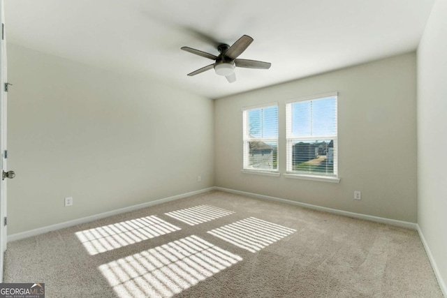 empty room with a ceiling fan, carpet floors, and baseboards