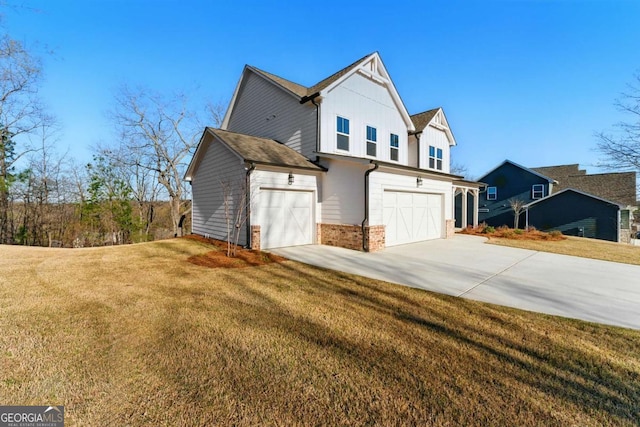 view of side of home with a yard, a garage, brick siding, and concrete driveway