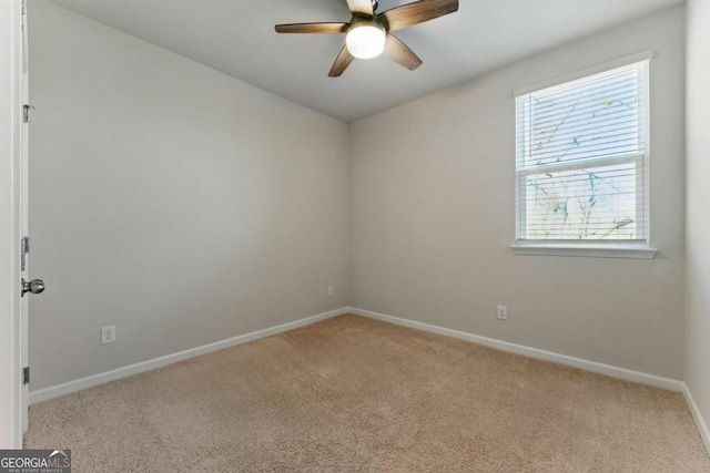 spare room with light carpet, baseboards, and ceiling fan