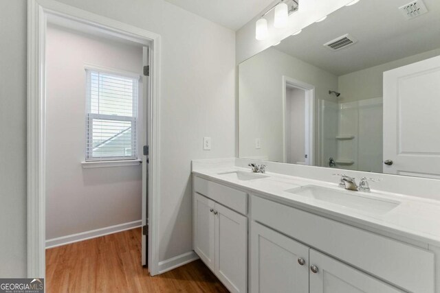full bathroom featuring visible vents, a sink, and a shower