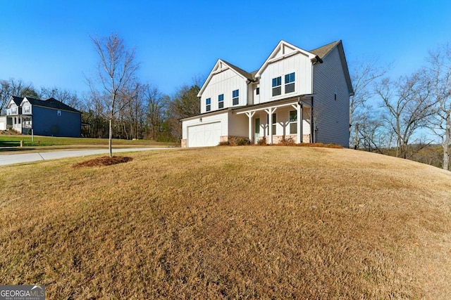 modern farmhouse style home featuring an attached garage, a front lawn, board and batten siding, driveway, and a porch