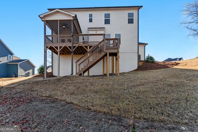 back of property with a lawn, a wooden deck, and stairway