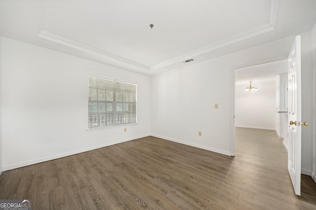 112 Bentley Pl, Tucker, GA 30084 - unfurnished room with an inviting chandelier, ornamental molding, baseboards, a raised ceiling, and wood finished floors