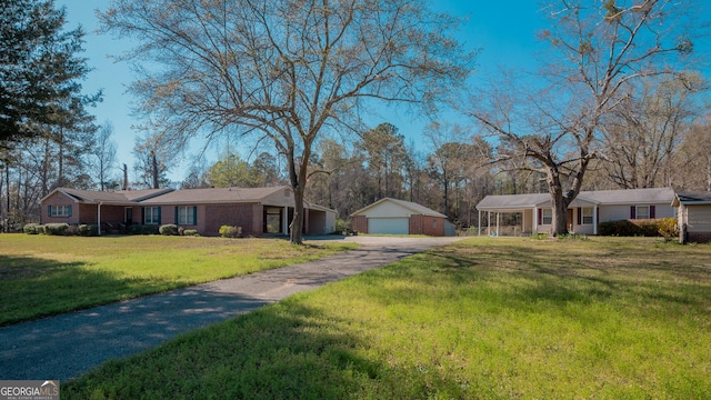 view of front of property with a front yard, an outbuilding, and a detached garage