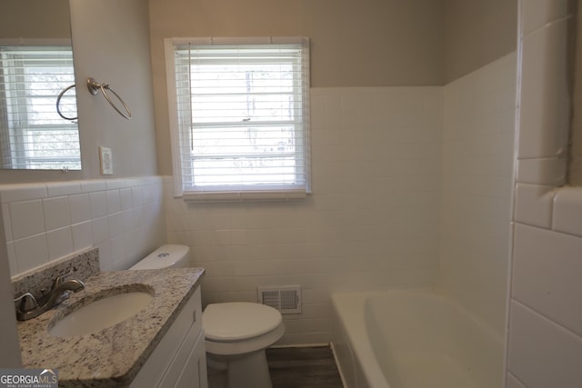 619 Church St NW, Atlanta, GA 30318 - bathroom featuring a wainscoted wall, toilet, vanity, visible vents, and tile walls