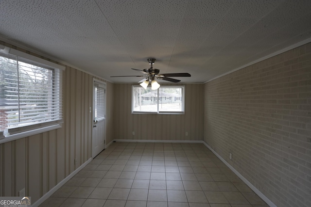 1923 Rosewood Rd, Decatur, GA 30032 - unfurnished room with baseboards, a ceiling fan, brick wall, and light tile patterned floors