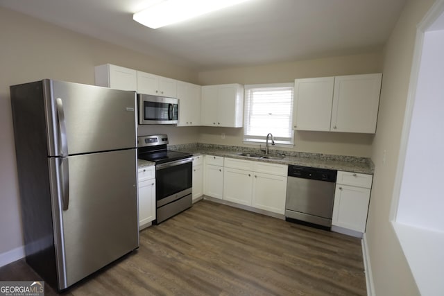 1923 Rosewood Rd, Decatur, GA 30032 - kitchen featuring light stone counters, a sink, appliances with stainless steel finishes, white cabinets, and dark wood-type flooring