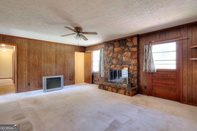 unfurnished living room with carpet flooring, a textured ceiling, a fireplace, and ceiling fan