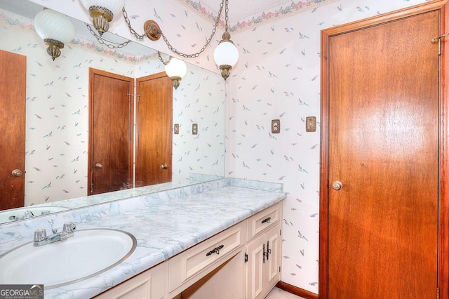 bathroom with wallpapered walls and vanity