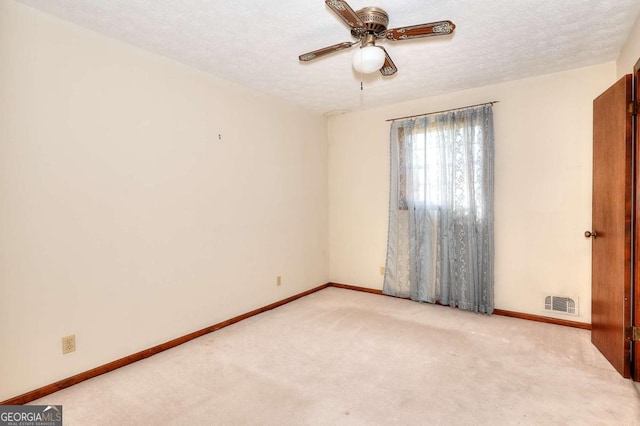 carpeted empty room with baseboards, visible vents, ceiling fan, and a textured ceiling
