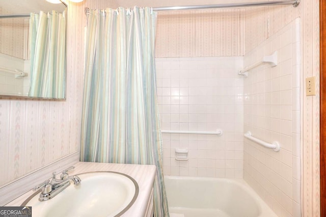full bathroom with vanity, wallpapered walls, and shower / tub combo