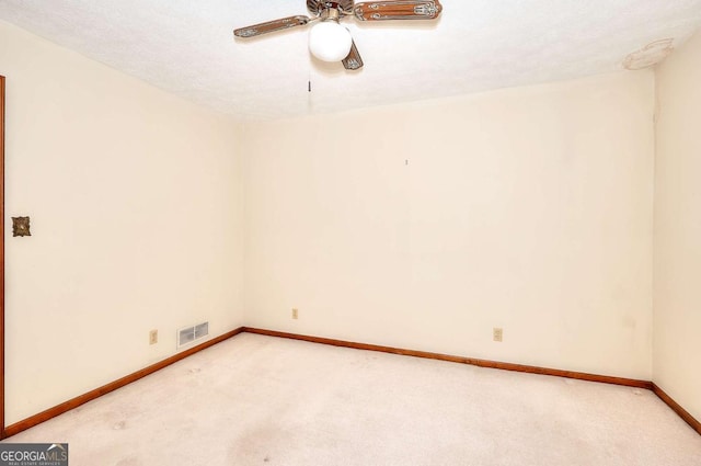 unfurnished room featuring baseboards, visible vents, a ceiling fan, and light carpet