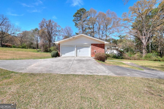 view of side of home with driveway, brick siding, a garage, and a yard