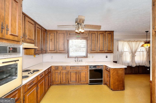 kitchen with white appliances, ceiling fan, under cabinet range hood, a sink, and brown cabinetry
