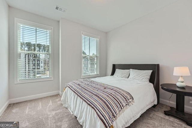 carpeted bedroom featuring visible vents and baseboards