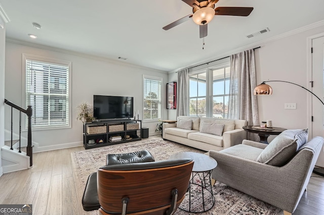 living area featuring visible vents, crown molding, and wood finished floors