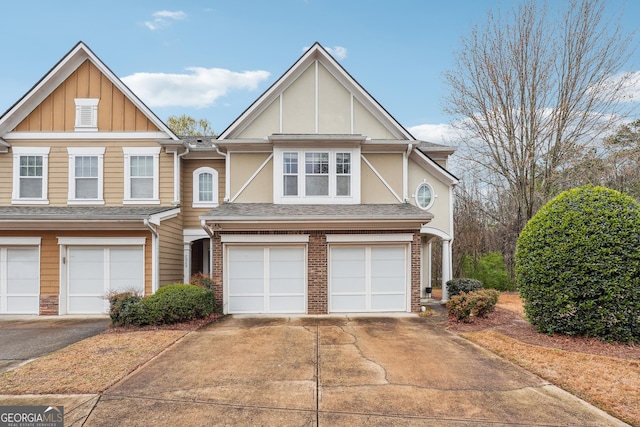 view of front of house featuring driveway, stucco siding, an attached garage, and brick siding