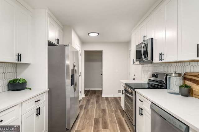 3069 Thrasher Cir, Decatur, GA 30032 - kitchen with stainless steel appliances, white cabinetry, backsplash, wood finished floors, and light countertops