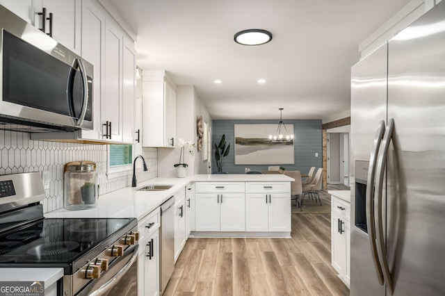 3069 Thrasher Cir, Decatur, GA 30032 - kitchen featuring stainless steel appliances, white cabinetry, light wood finished floors, a chandelier, and recessed lighting