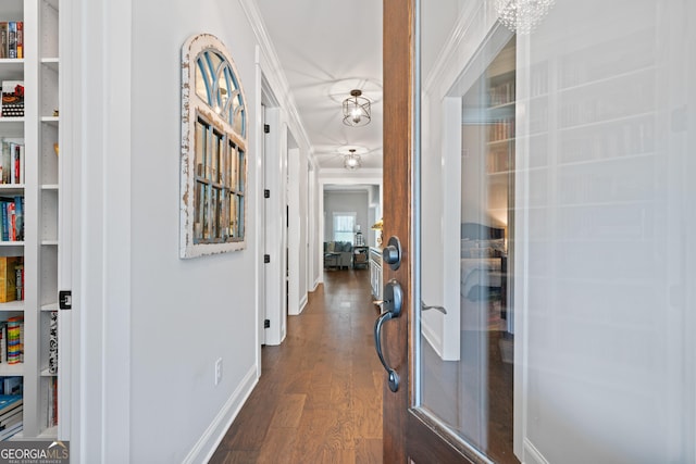 hall featuring dark wood-style flooring, ornamental molding, and baseboards