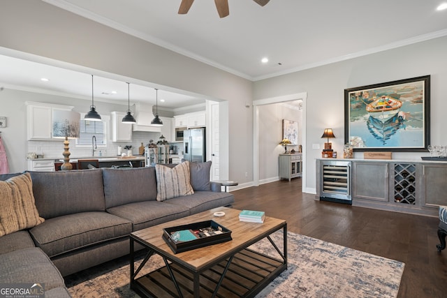 living area with dark wood-type flooring, ceiling fan, wine cooler, and crown molding