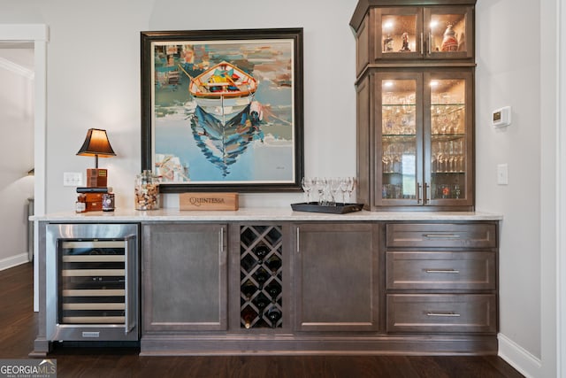 bar featuring dark wood-style floors, wine cooler, a dry bar, and baseboards