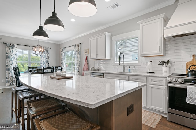 kitchen with custom range hood, stainless steel appliances, ornamental molding, a sink, and white cabinets