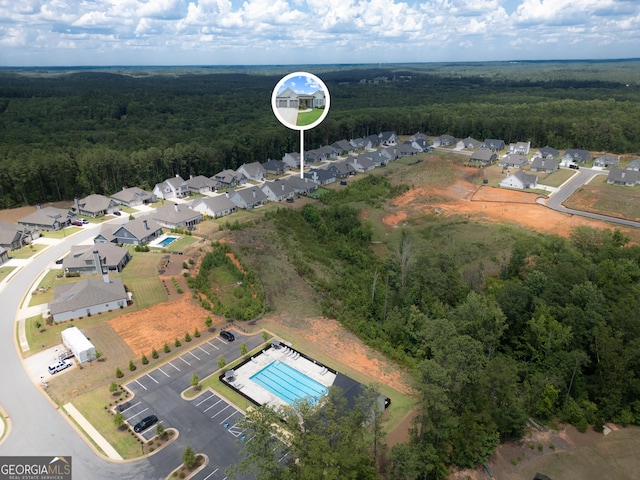 drone / aerial view featuring a wooded view