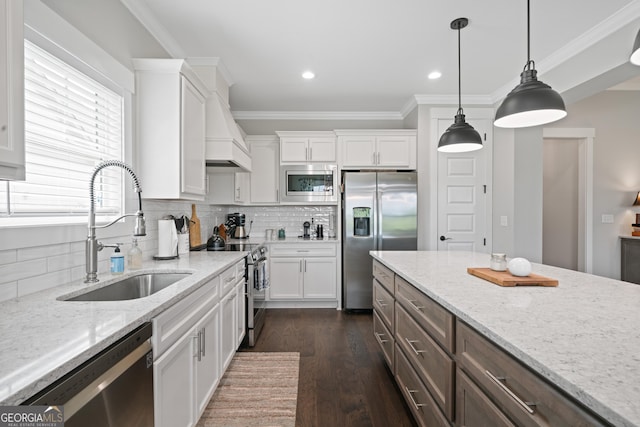 kitchen featuring white cabinets, a sink, ornamental molding, and appliances with stainless steel finishes