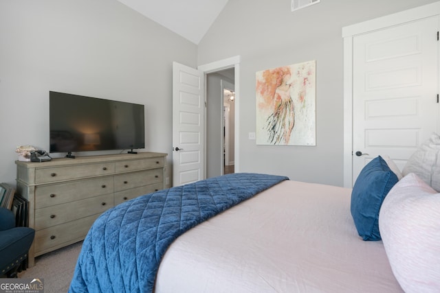 carpeted bedroom featuring visible vents and vaulted ceiling