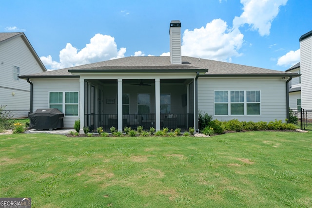 rear view of property featuring a lawn, a sunroom, a chimney, and fence