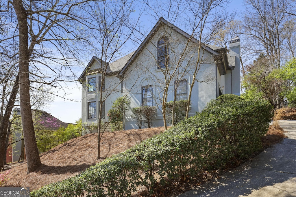 10660 Thatcher Way, Johns Creek, GA 30097 - view of side of home featuring a chimney and stucco siding