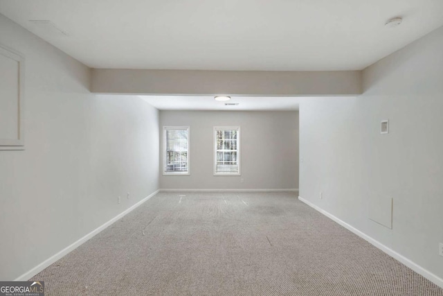 empty room featuring light carpet and baseboards