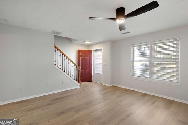 entryway with baseboards, visible vents, wood finished floors, and stairway