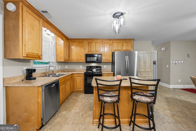 104 Nugget Ln, Ellijay, GA 30540 - kitchen with black appliances, a sink, light countertops, a breakfast bar, and a center island