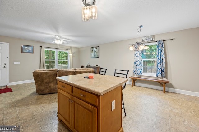 104 Nugget Ln, Ellijay, GA 30540 - kitchen featuring brown cabinetry, a kitchen island, baseboards, and light countertops