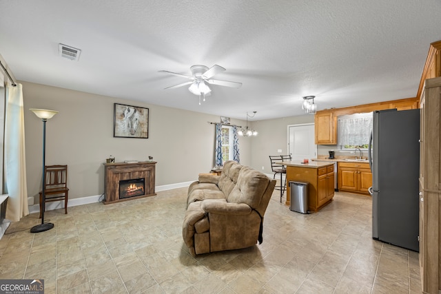 104 Nugget Ln, Ellijay, GA 30540 - living area with ceiling fan, plenty of natural light, a chandelier, a glass covered fireplace, and a textured ceiling