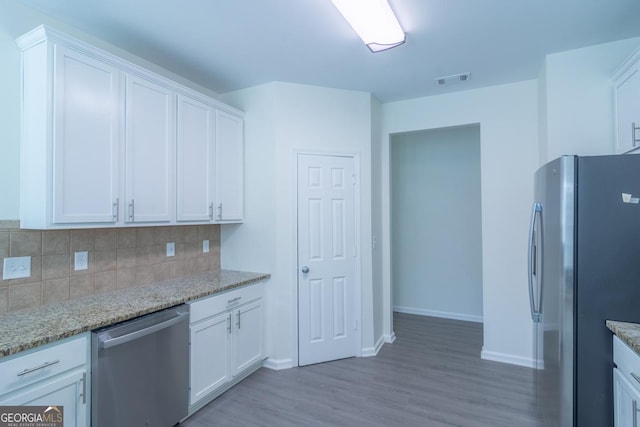 kitchen with white cabinets, stainless steel appliances, and tasteful backsplash