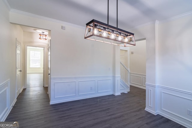 unfurnished dining area featuring dark wood-style floors, a decorative wall, and crown molding