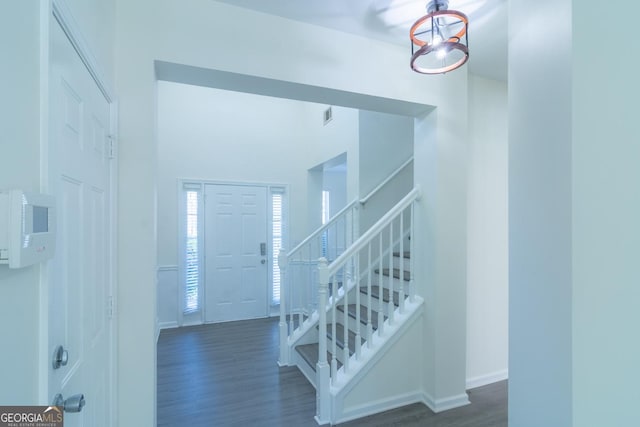 entrance foyer featuring stairs, baseboards, and dark wood-style floors