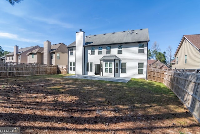rear view of house featuring a chimney, a fenced backyard, a residential view, a patio, and a lawn