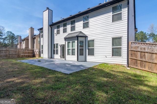 rear view of property with fence, a yard, and a patio area