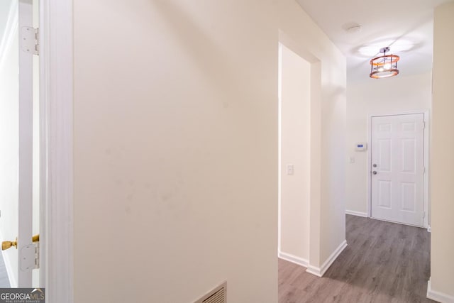 hall featuring baseboards and wood finished floors