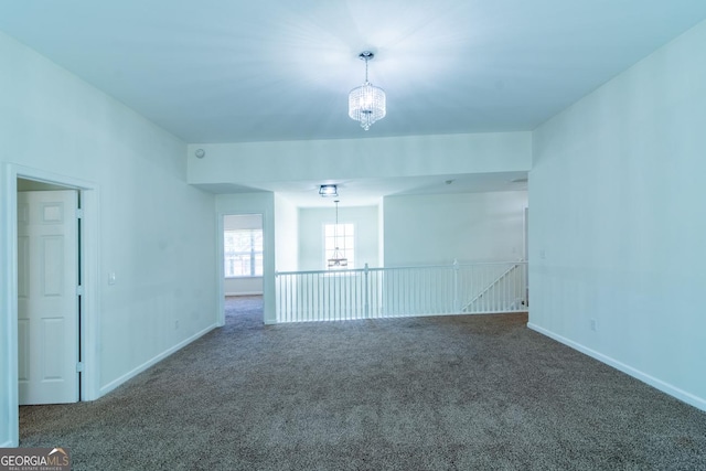 empty room with baseboards, carpet flooring, and an inviting chandelier
