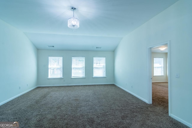 empty room featuring visible vents, carpet, baseboards, vaulted ceiling, and a notable chandelier
