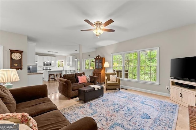 5055 Hamptons Club Dr, Alpharetta, GA 30004 - living area with ceiling fan and healthy amount of natural light