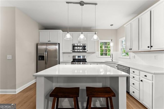 5055 Hamptons Club Dr, Alpharetta, GA 30004 - kitchen featuring stainless steel appliances, light wood-type flooring, a kitchen breakfast bar, and decorative backsplash