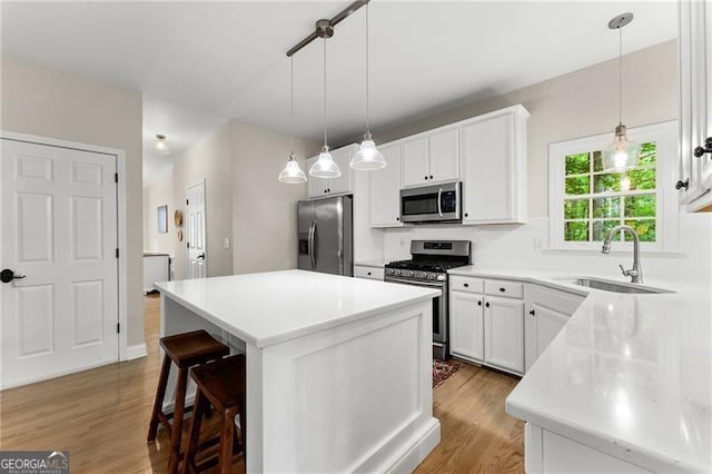 5055 Hamptons Club Dr, Alpharetta, GA 30004 - kitchen with appliances with stainless steel finishes, light wood-style flooring, a kitchen island, and white cabinets