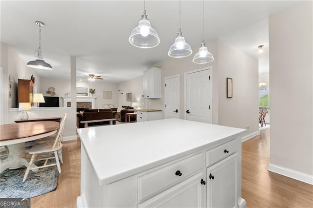 5055 Hamptons Club Dr, Alpharetta, GA 30004 - kitchen featuring a center island, a ceiling fan, white cabinetry, and light wood-style floors