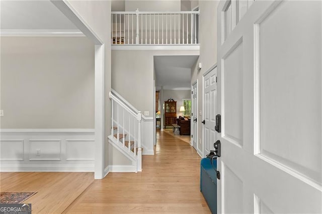5055 Hamptons Club Dr, Alpharetta, GA 30004 - foyer entrance featuring stairway, light wood-style flooring, a wainscoted wall, ornamental molding, and a decorative wall